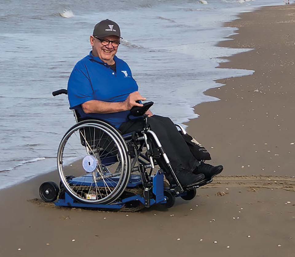 Rollstuhlfahrer mit Raupen Antrieb am Strand
