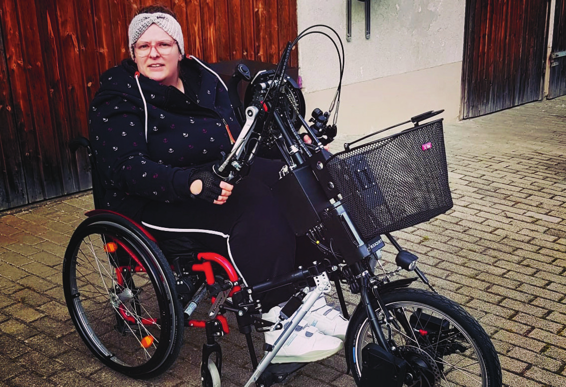 Frau im Rollstuhl mit Handbike